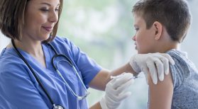 boy receiving vaccine from nurse