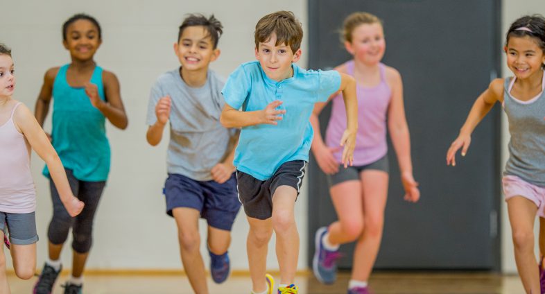 young kids running in school gym