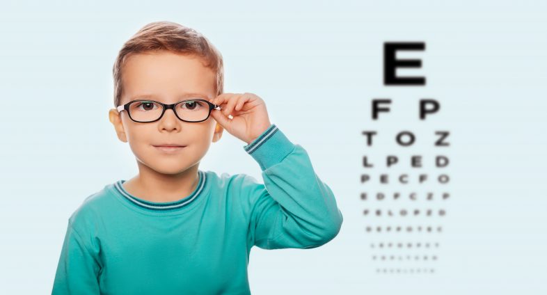 boy with glasses and eye test chart